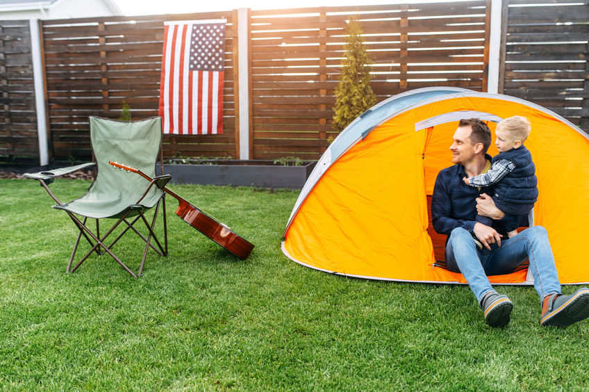 Father and son in their backyard with a tent set up.