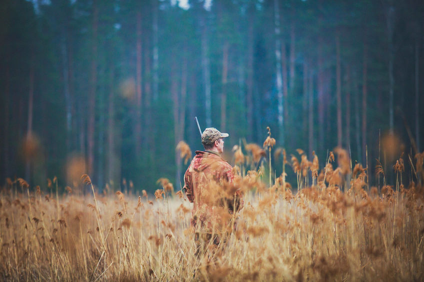 hunter standing in field properly dressed for tick prevention