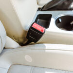 cropped image of leather car seats and retractable platform of seatbelt
